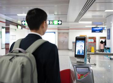 A man going through a turn-style equipped with facial recognition 