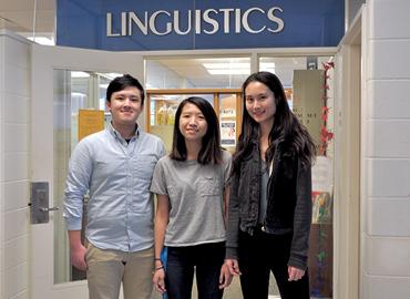 Three students stand in-front of the Linguistics office.