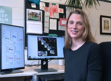 Morgan Barense sitting in front of two computer screens