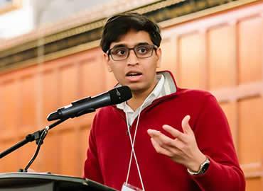 Manula Adhihetty speaking at a podium