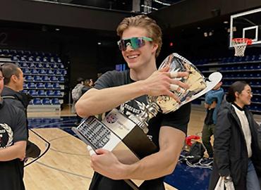 Matthew Kieffer on a volleyball court holding a trophy