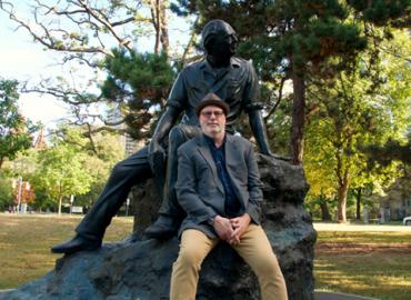 Nick Mount with the statue of Al Purdy at Queen’s Park. 