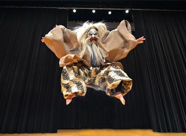  a costumed dancer leaping very high into the air!