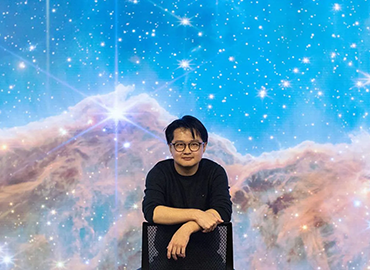 Peter Ma standing in front of a space backdrop
