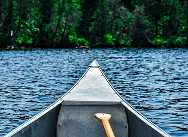 the front end of a canoe in the water