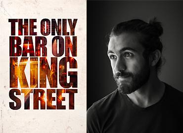 A photo of Eli Meadow Ramraj and a poster that says, &amp;quot;The Only Bar of King Street.&amp;quot;