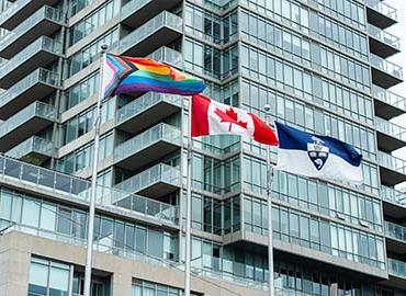 Progress Pride flag and the Canadian and U of T flag fly over Varsity Stadium 