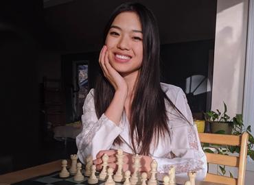 Qiyu Zhou in front of a chess board