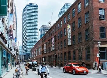 A man biking in the road in front of 401 Richmond Street