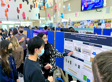 a crowd of people milling around research posters