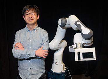 Jiannan Li standing with the robot