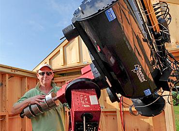 Stuart Heggie standing in front of a large telescope.