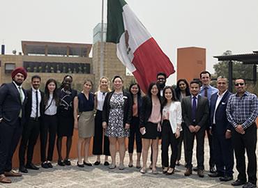 Students on a rooftop in front of a big Mexican flag