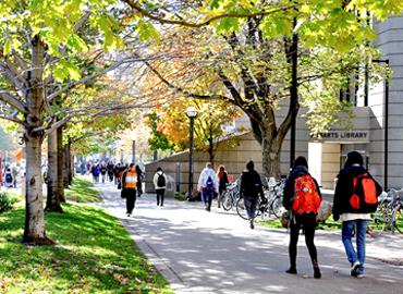 Students walking outside of Robarts Library on a sunny fall day
