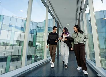 Three students walking down a hallway.
