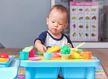 toddler playing with baby toys
