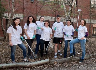 Trash team outreach volunteers pose in matching t-shirts during a litter clean-up initiative