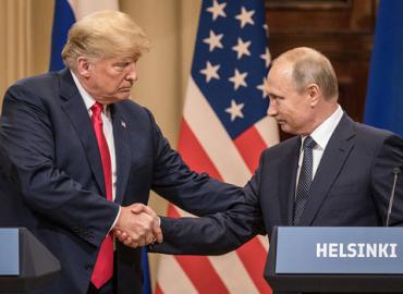 Trump and Putin shake hands near a podium