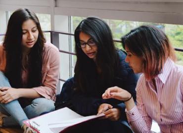 Three people reviewing a document.