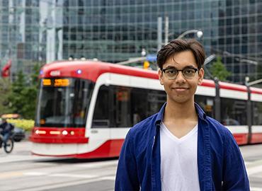 Zarif Ali on a city street in front of a TTC streetcar