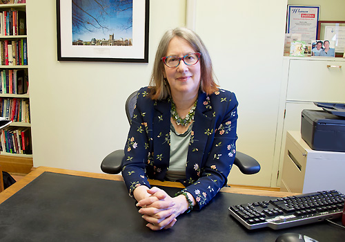 Sylvia Bashevkin sitting at her desk with her arms clasped atop it