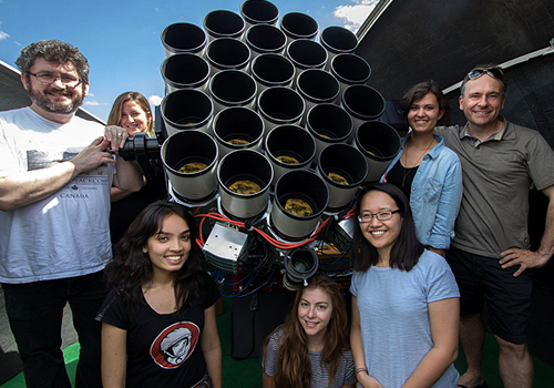 U of T Professor Robert Abraham (left) and Yale Professor Pieter van Dokkum (right), with their team of graduate students from both universities. They are standing with one-half of the 48-lens Dragonfly array at its home site in New Mexico.