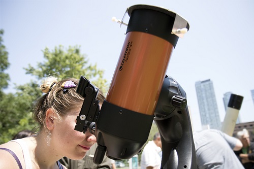 A woman looking into a telescope