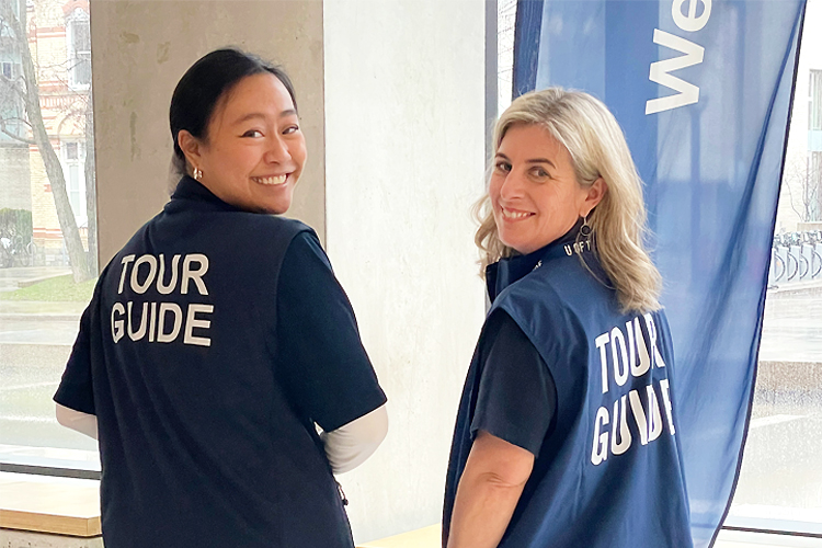 Student Chelsea Wang posing with the dean in U of T Tour Guide tops