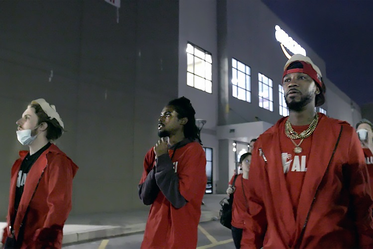 A still from the movie Union - three men standing in front of a warehouse