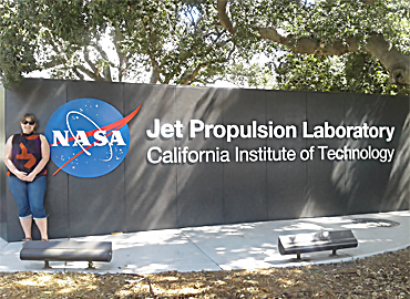 Camilla Urbaniak standing in front of a NASA sign