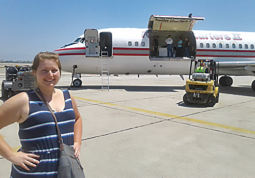 Camilla Urbaniak standing on airport tarmac in front of a jet plane
