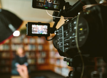 An up close look at a camera and a person blurred in the background.