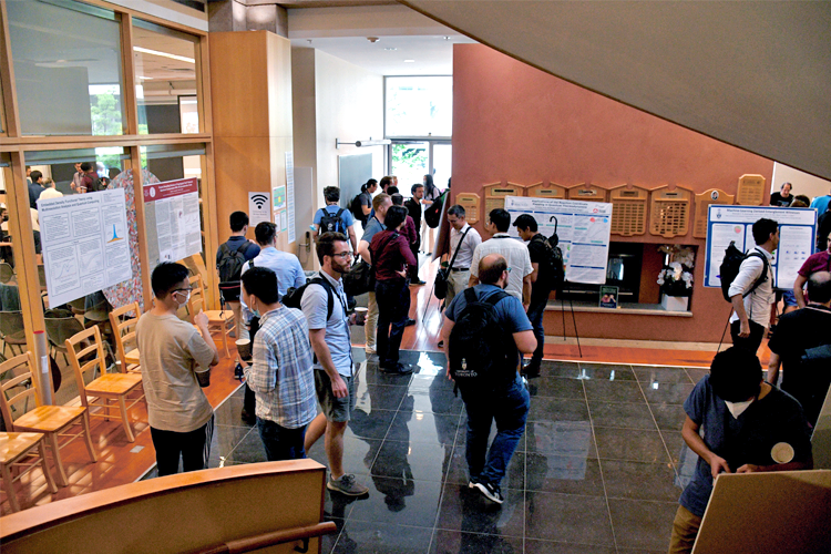 Looking down stairs at the poster session - many people milling about!