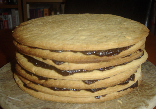 Layers of yellow cake with chocolate in the middle of each layer.