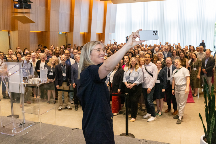 Melanie Woodin takes a selfie with a large audience.